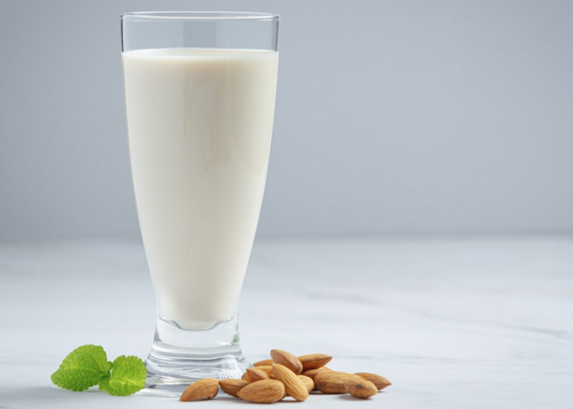 Almond milk in a glass with almonds to the side